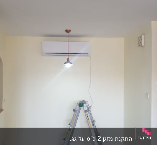 מזגן מותקן על קיר עם סולם מתחתיו